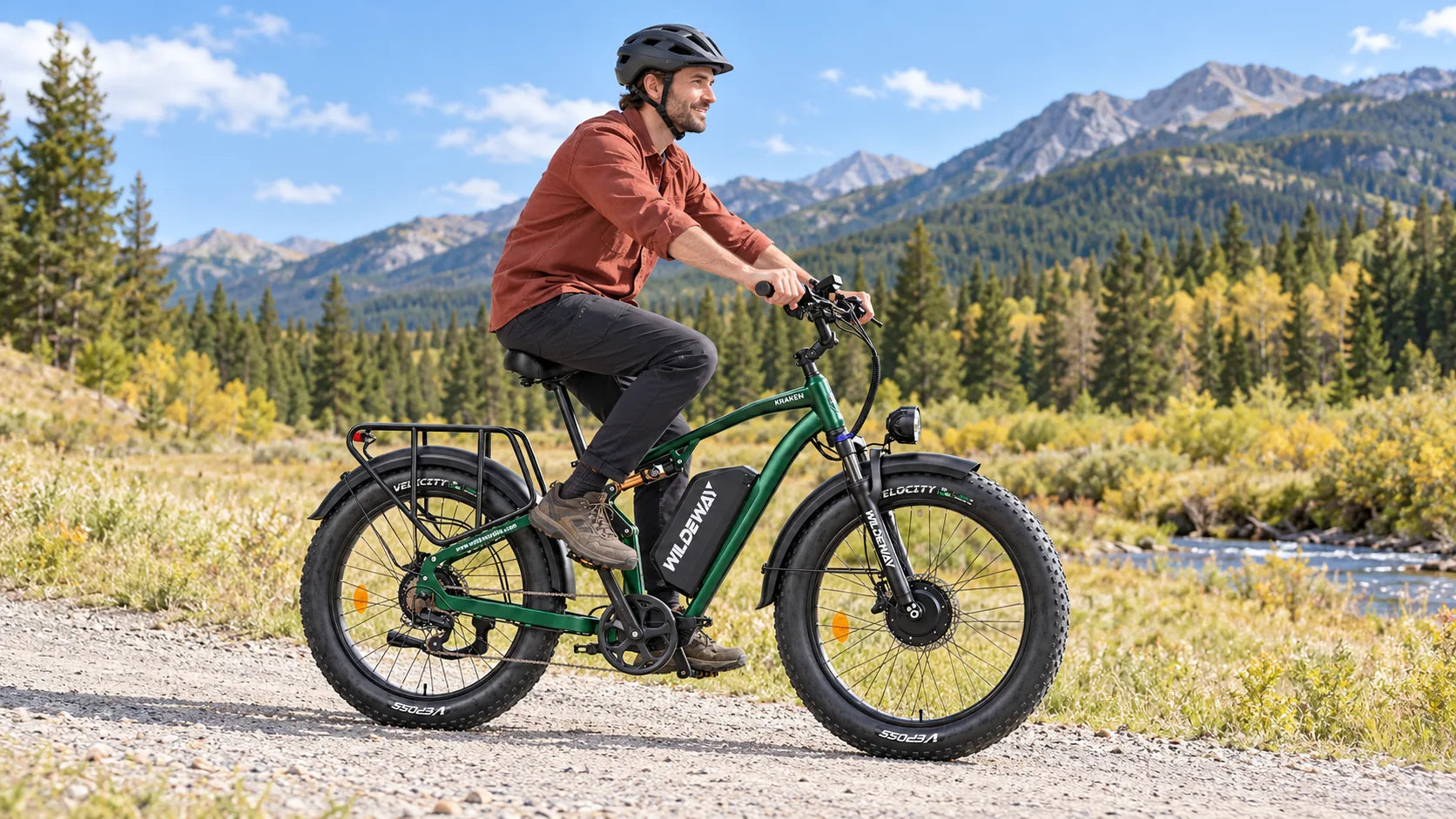 Helmeted rider on a green KRAKEN along a sunny gravel trail in the foothills